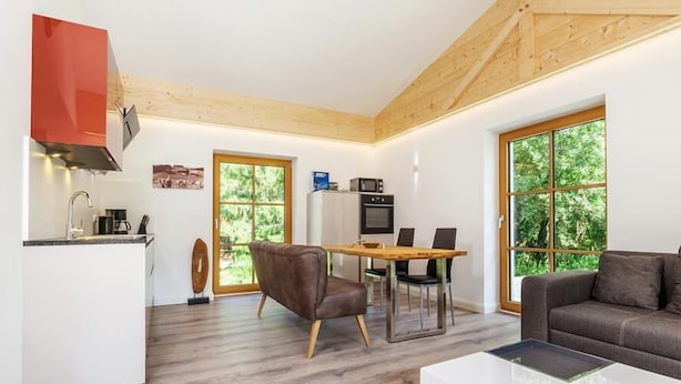 Eine moderne Küche mit Essbereich, einer Couch und einem großen Fenster.
