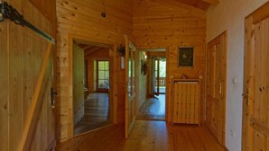 A wooden interior with a hallway leading to a door, a window, and a door with a lock. - Ferienwohnung Dahoam für 2-6 Personen, 78 qm (Marktschellenberg)