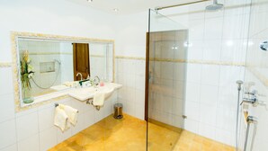 A bathroom with a glass-enclosed shower, a sink with a mirror, and a tiled floor. - Ferienwohnung -3- (35qm), Terrasse, Küche extra, 1 Schlaf- und 1 Wohnzimmer, max 2 Personen (Ruhpolding)