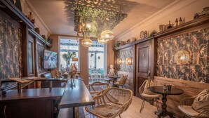 A bar area with wicker chairs, a long counter, and a decorative ceiling. - Apartment Montana for 2 persons and east-facing balcony, 40 sqm (Bad Reichenhall)