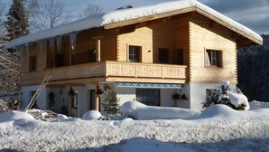 A wooden chalet with a balcony, surrounded by snow. - Ferienwohnung van Hees, "Benz Eck" (Reit im Winkl)