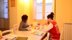 Two people sitting at a table with a window in the background. - B&B Su Niu (Cagliari)