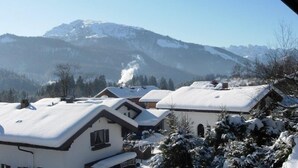 A snow-covered village with traditional houses and a mountain in the background. - 2-Raum-Ferienwohnung, 47m², Dusche/WC, Balkon und Küche extra (Reit im Winkl)