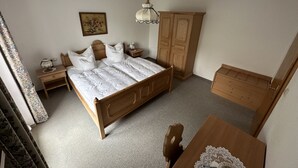 A bedroom with a wooden bed, nightstands, a wardrobe, and a desk. - 2-Raum-Ferienwohnung, 47m², Dusche/WC, Balkon und Küche extra (Reit im Winkl)