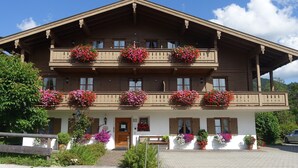 En traditionel chalet-bygning med flere balkoner pyntet med blomsterkasser.