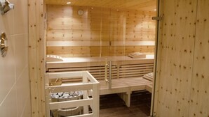 Un sauna avec des bancs en bois et une porte en verre.