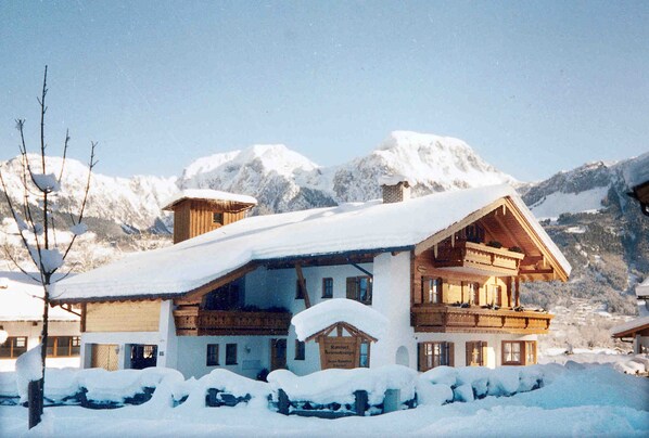 A chalet-style building with a sloped roof, wooden balconies, and a sign indicating it is a mountain resort.