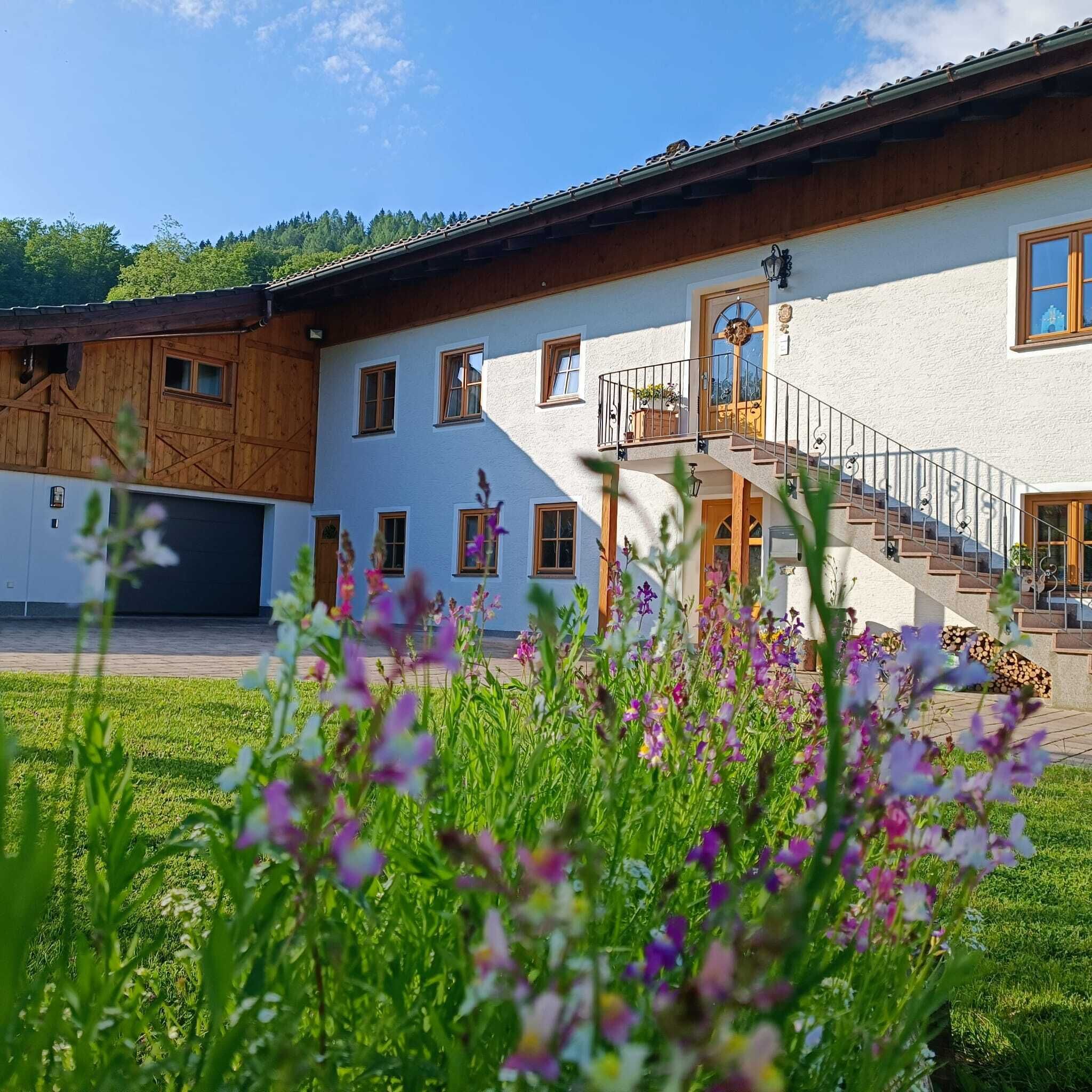Un edificio a due piani con rivestimento in legno e un balcone.