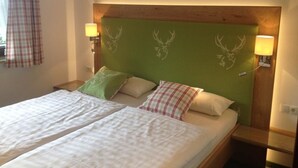A double bed with a green headboard, two bedside lamps, and plaid curtains. - Ferienwohnung Nr. 2 Kehlsteinblick, 1 bis 2 Personen, 45 qm, 1 Schlafzimmer, Wohnküche und Balkon (Schönau am Königssee)