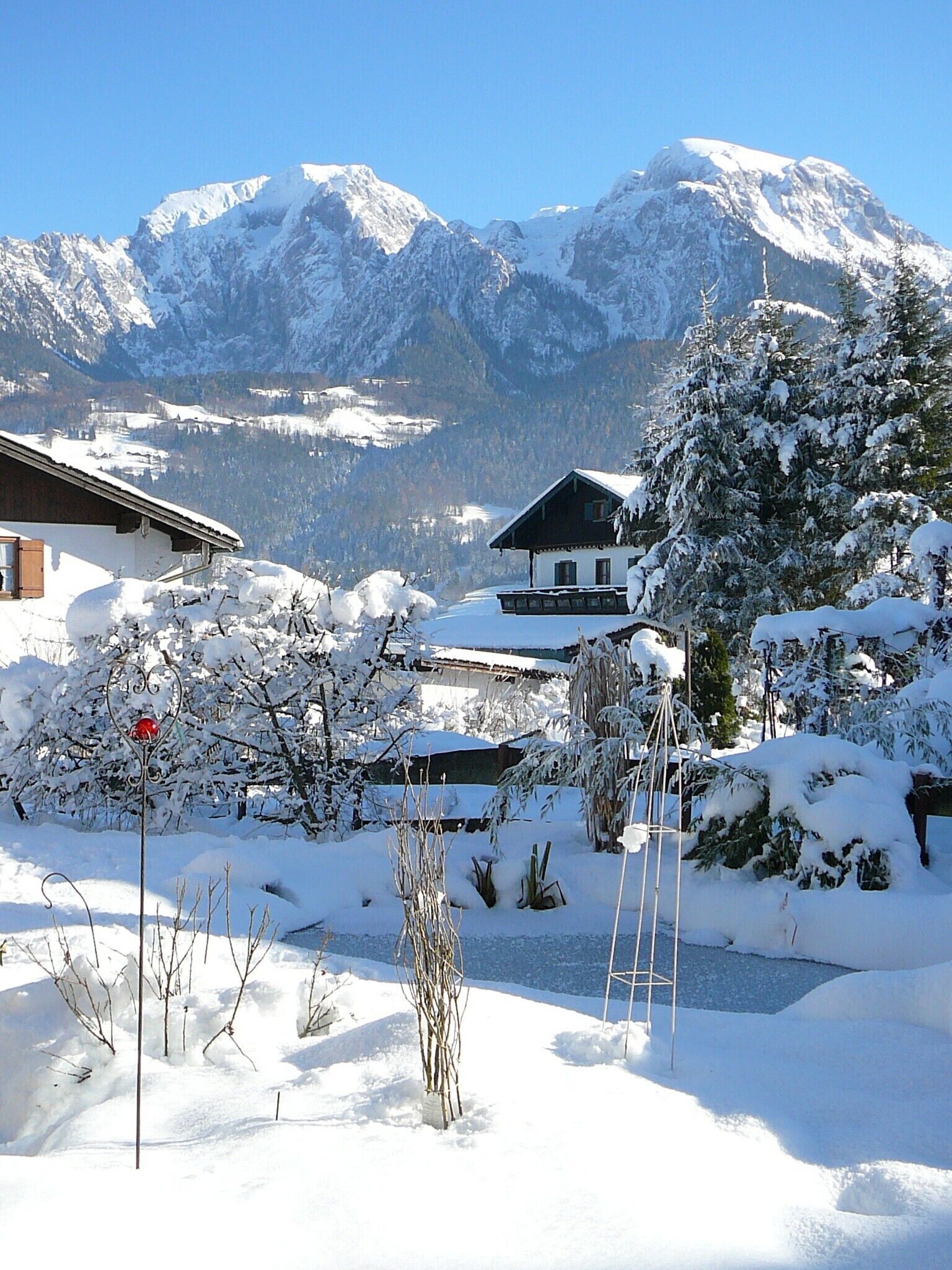 Eine verschneite Berglandschaft mit einem Chalet im Vordergrund.