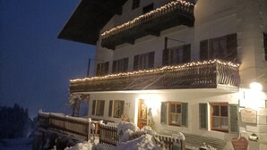 Ein zweistöckiges Gebäude mit Balkon, verschneitem Grund und einem Schild mit der Aufschrift 'Moor'.
