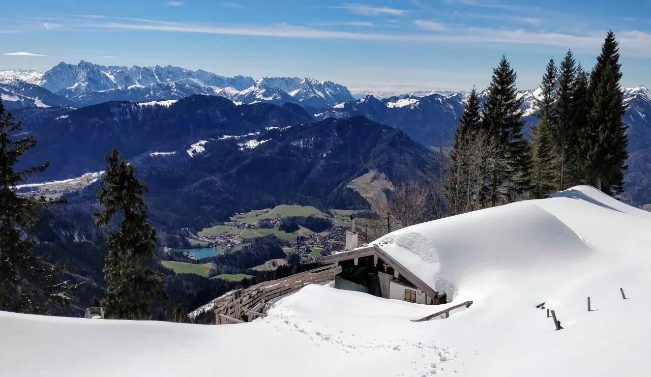 A snow-covered mountain with a wooden cabin and a ski slope.