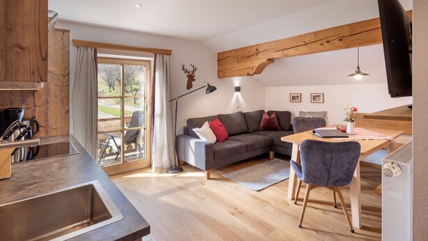 Un espacio habitable moderno con cocina, comedor y un amplio ventanal.