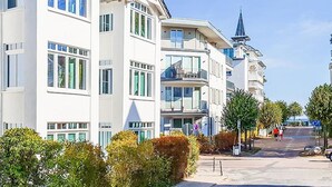 A multi-story residential building with balconies, a church spire, and a clear sky. - Apartment 013 / 1st floor with balcony/ Only bookable for 4 persons - Villa Meernixe - (Binz)
