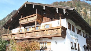 En traditionel bygning i alpehusstil med en træbalkon og et skilt, der siger "Haus Alpenlicht".