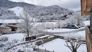 Un quartier résidentiel avec des maisons recouvertes de neige, une clôture en bois et une route.