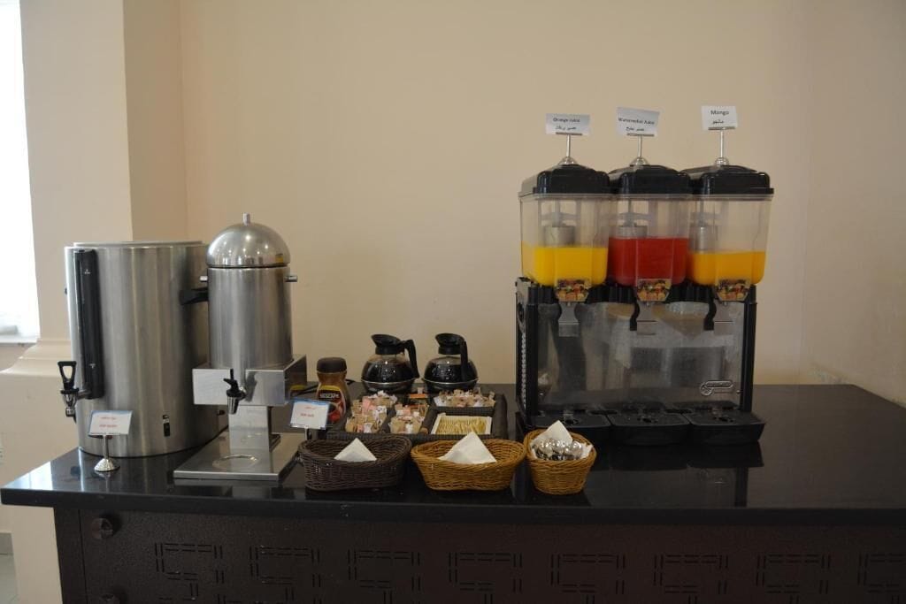 Un espace dédié au café, comprenant une machine à café, un distributeur de boissons et différents types de dosettes de café.
