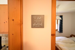 A wooden door frame with a wall-mounted sign that reads "Nimm dir Zeit, für die Dinge, die du schnell machst...".