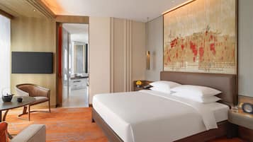 A modern hotel room with a large bed, a desk with a chair, a flat-screen TV, and a large artwork on the wall.