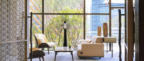 A modern interior with a sofa, chairs, a coffee table, and a lamp.