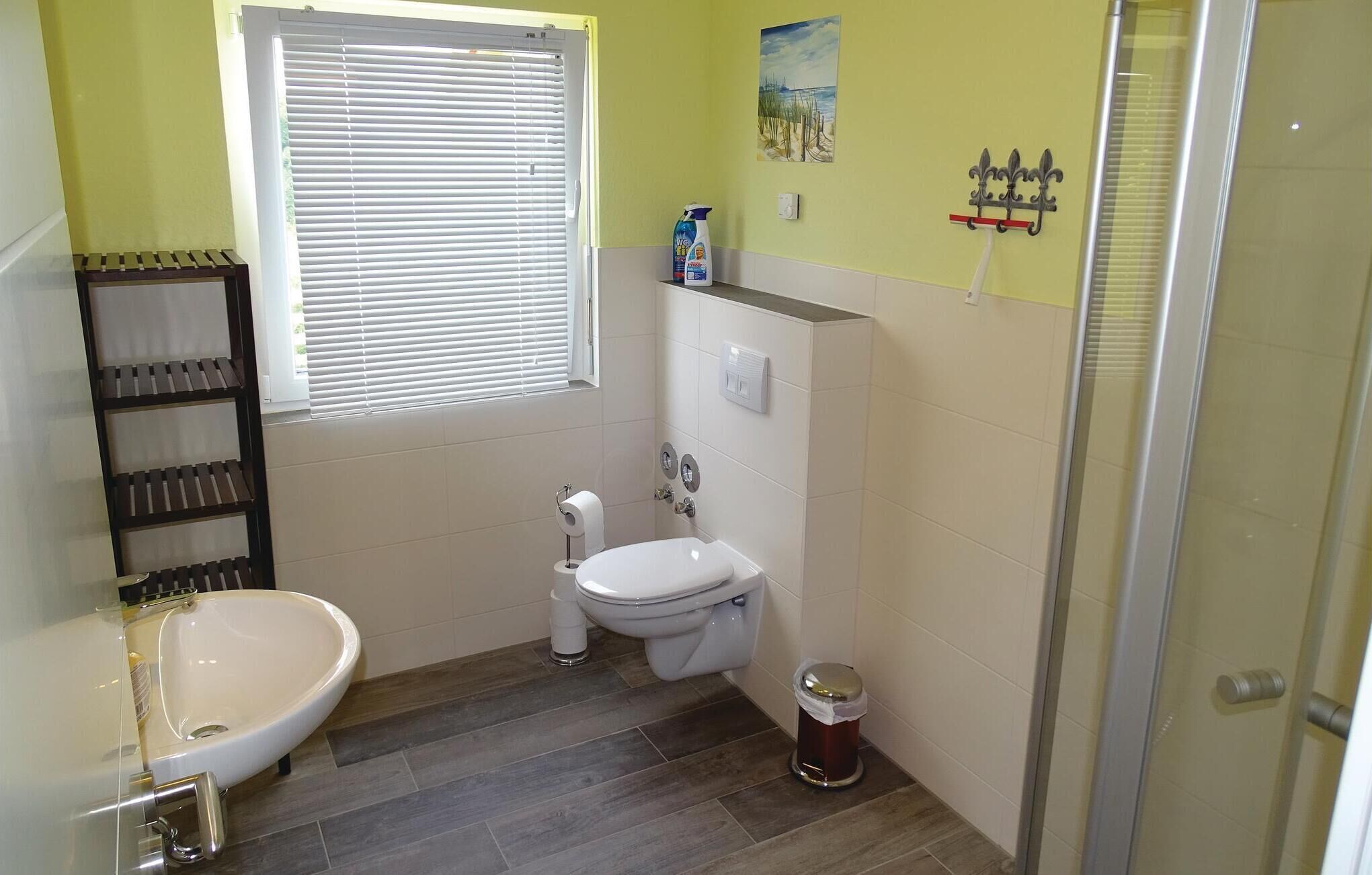 A compact bathroom with a toilet, sink, and shower.