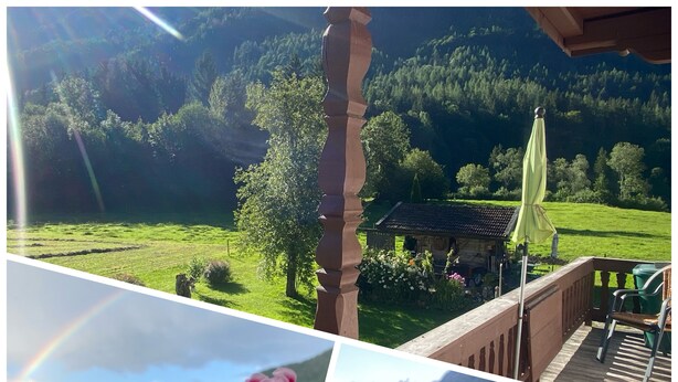Un jardín con un pabellón, un vaso de agua con rodaja de limón y flores rosadas.