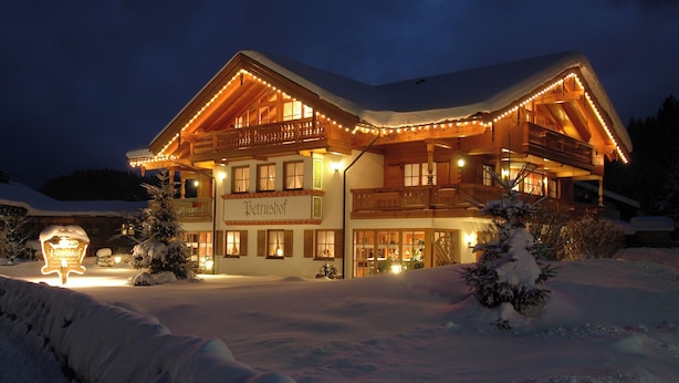 A large, two-story wooden building with a sign reading "Petrushof" in the center. - Ferienwohnung 4, 2 Personen, 50 qm., 1 Schlafzimmer, DU/WC, TV, Zimmersafe, Balkon (Oberwössen)
