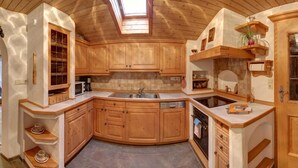 A compact kitchen with wooden cabinets, a built-in oven, and a skylight. - Ferienwohnung Martina für 5 Personen, 3 Schlafzimmer mit Balkon, 90 m² (Inzell)