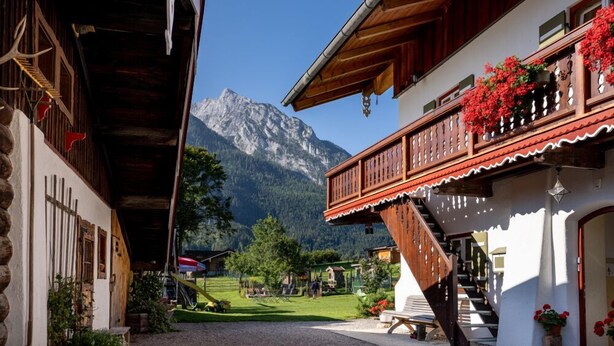 A traditional wooden building with a balcony, a mountain backdrop, and a clear sky. - Double room no. 5, apartment, 1-2 persons, 40 sqm, west-facing balcony, W-LAN (Ramsau bei Berchtesgaden)