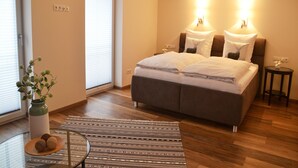 Een slaapkamer met een bed, nachtkastjes, een raam en een deur.