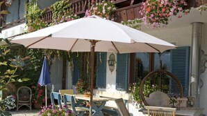 An outdoor patio with a table and chairs, surrounded by potted plants and flowers. - 3. Fewo Hochlerch, 28 qm, 1-2 Pers., 1 Schlafzimmer, 1 Wohnküche, Süd-Balkon (Grassau)