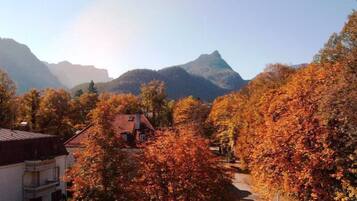 Eine Berglandschaft mit Herbstlaub, einer Straße und einem Gebäude mit Satteldach.