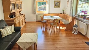 Uma sala de estar aconchegante com uma mesa de jantar de madeira, um banco e um sofá de couro preto.