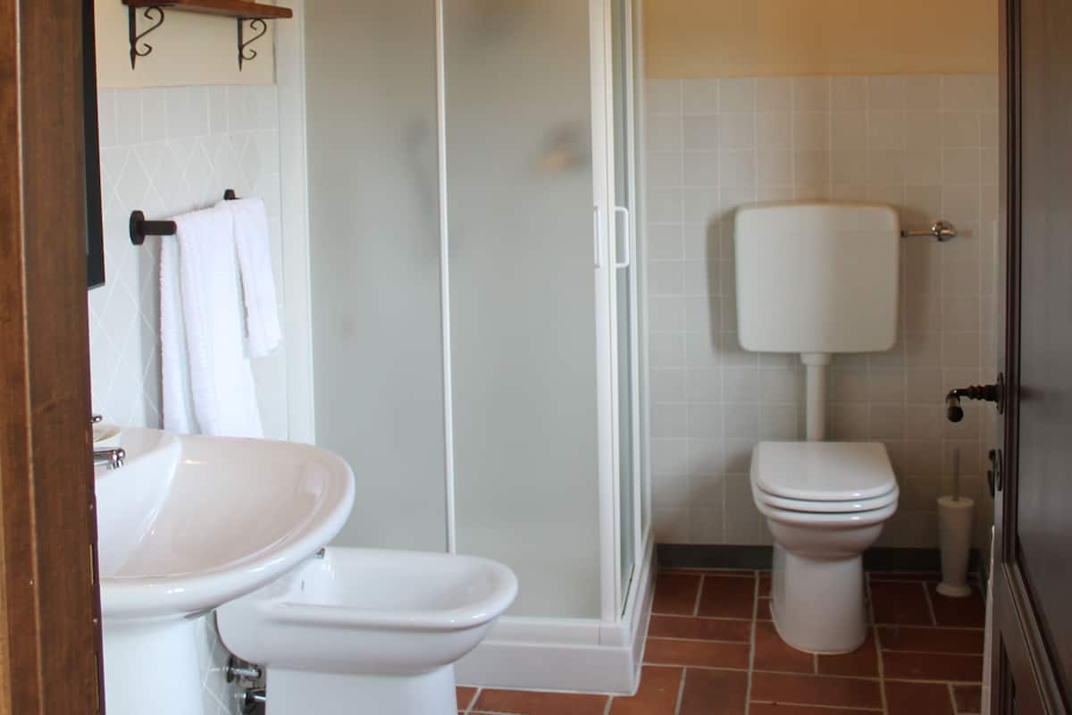 Un baño con cabina de ducha, inodoro y lavabo.