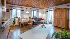 Ein gemütliches Wohnzimmer mit Essbereich, Holzboden und einem großen Holzschrank.