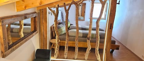 A room with a wooden bench, a sofa, and a unique tree branch structure.