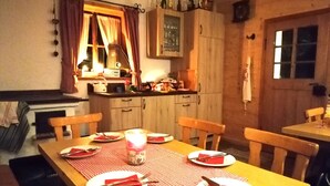 A dining area with a wooden table set for four, featuring red napkins and cutlery. - No. 2 Holiday apartment Hörndlwand 70sqm, balcony, 2 bedrooms, 1 bed-sitting room (Ruhpolding)