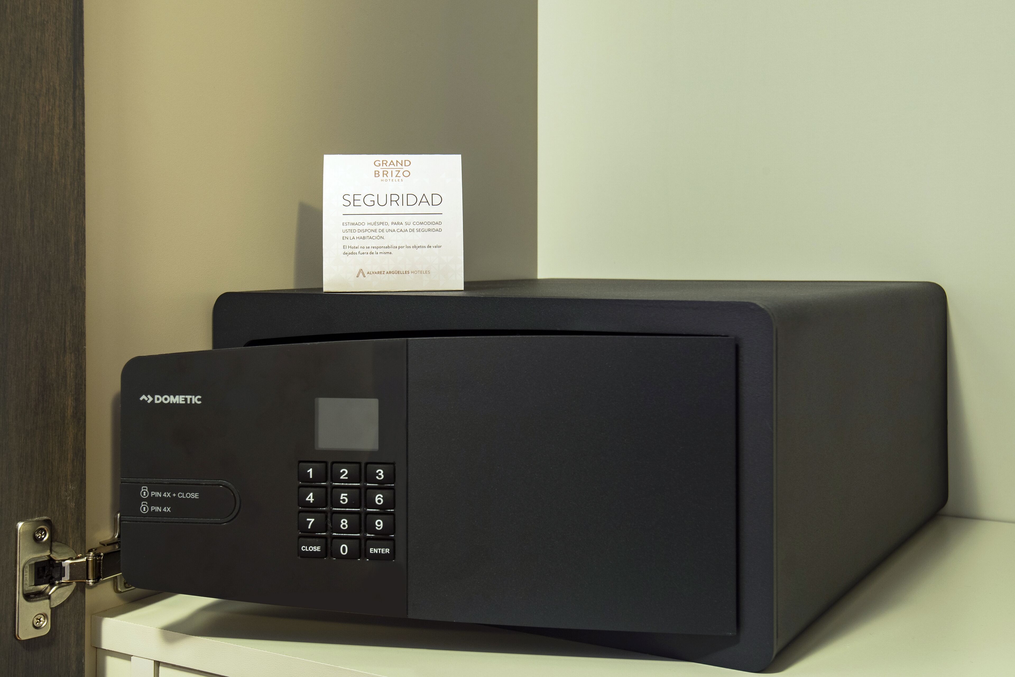 A black security keypad with a sign above it that reads "GRAND BRIZO SEGURIDAD".