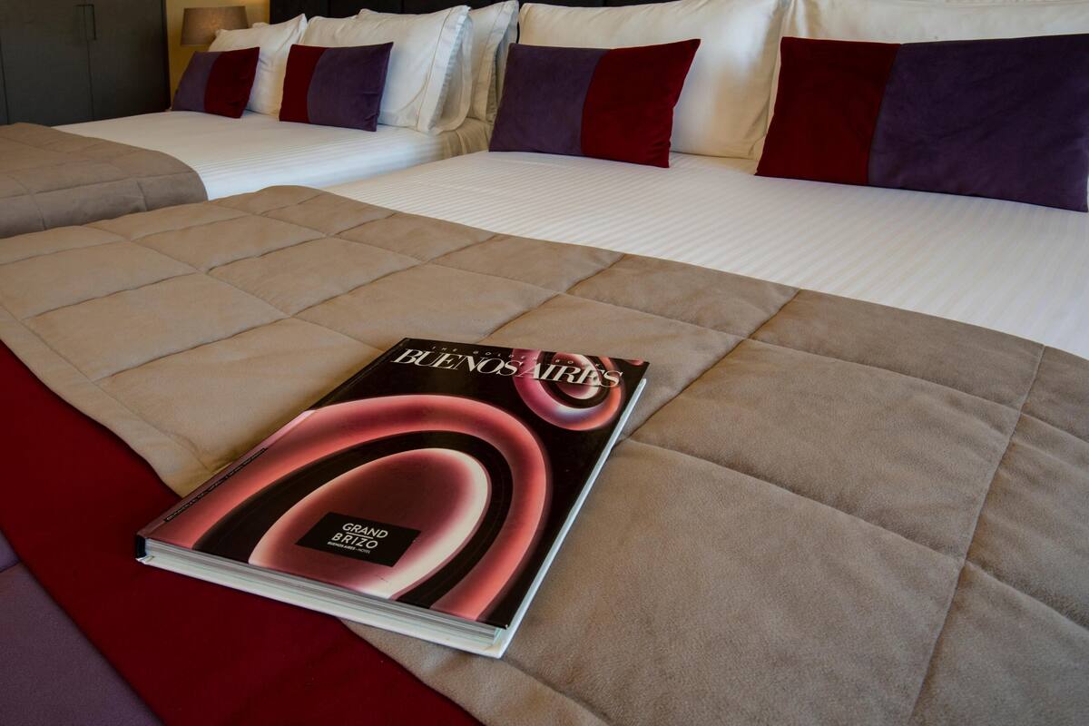 A bed with a magazine, pillows, and a headboard.