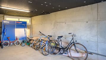 Un aparcamiento con bicicletas estacionadas contra la pared.