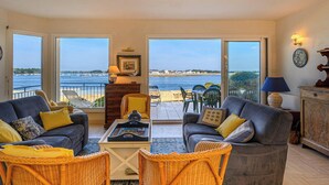 Un salon avec vue sur la mer, aménagé avec des canapés, des fauteuils et une table basse.