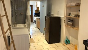 A kitchen with a refrigerator, sink, and cabinets.