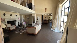 A spacious living room with a fireplace, a sofa, a coffee table, and a balcony.