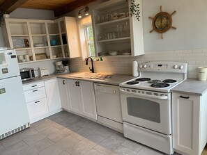 Enjoy cooking in this well-equipped kitchen with a central island, microwave, toaster, and large stove with four burners.