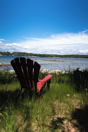Relax in a serene lakeside setting with a picturesque view of the water and surrounding landscape.