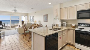 A kitchen with a built-in dishwasher, a stove, and a large island with a sink.