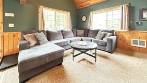 A cozy living room with a large L-shaped sectional sofa, a round coffee table, and a wooden ceiling. - 24 MI to YNP | ATV Trails | Near Big Springs (Island Park)
