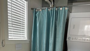 Een badkamer met toilet, wastafel en wasmachine.