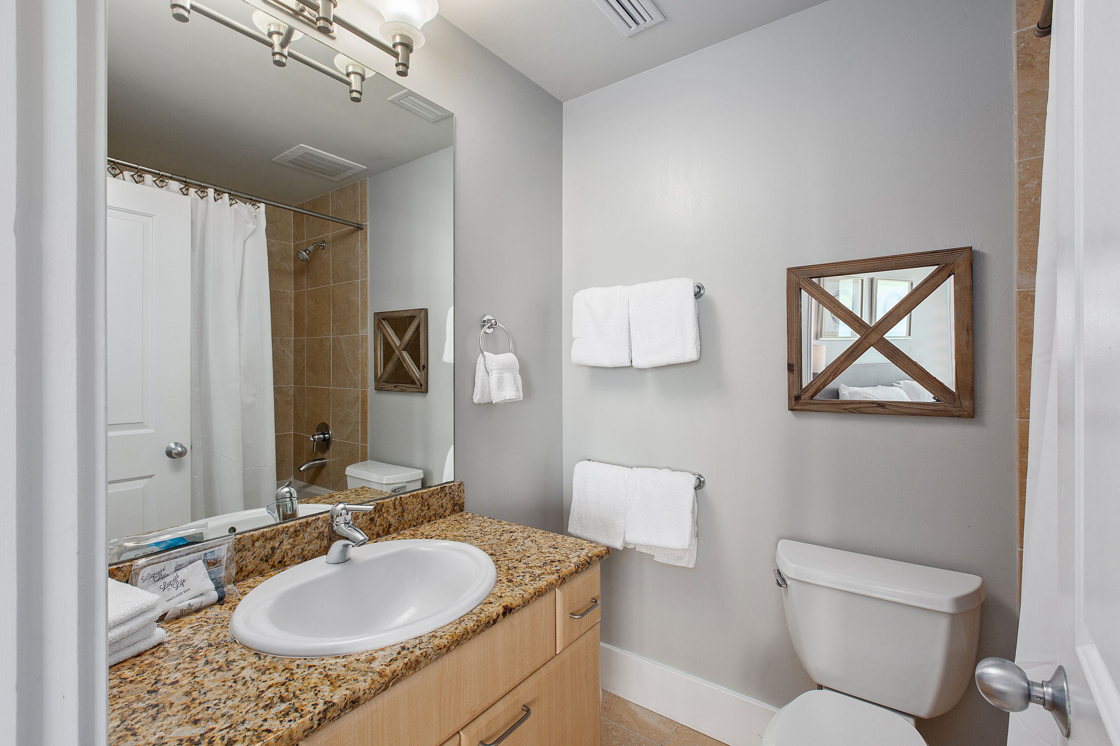 A bathroom with a sink, mirror, toilet, and towel rack.