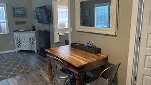 A dining area with a wooden table, metal chairs, a white cabinet, and a ceiling fan. - Coastal Charm!!!! Super cute and clean!! (Port St Joe)